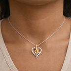 Necklace with a heart-shaped pendant featuring a gold and silver design on a person's neck.