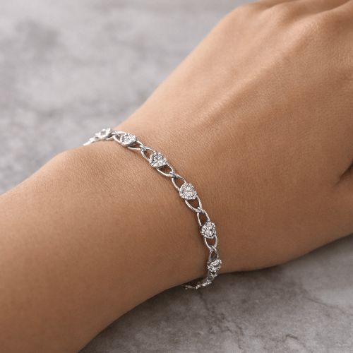 Silver bracelet on a wrist with a neutral background
