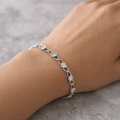 Silver bracelet on a wrist with a neutral background