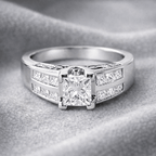 White gold ring with a large diamond and smaller diamonds on a gray background